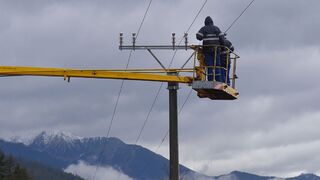 Elektromontéri opravujú elektrické vedenie poškodené víchricou.