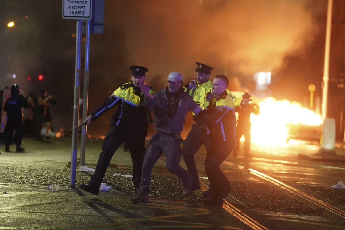 Polícia odvádza demonštranta počas nepokojov v Dubline.