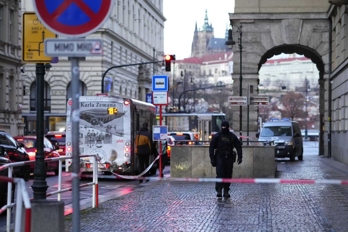 Policajt kráča pred budovou Filozofickej fakulty Univerzity Karlovej (FF UK) po streľbe v centre Prahy 22. decembra 2023.