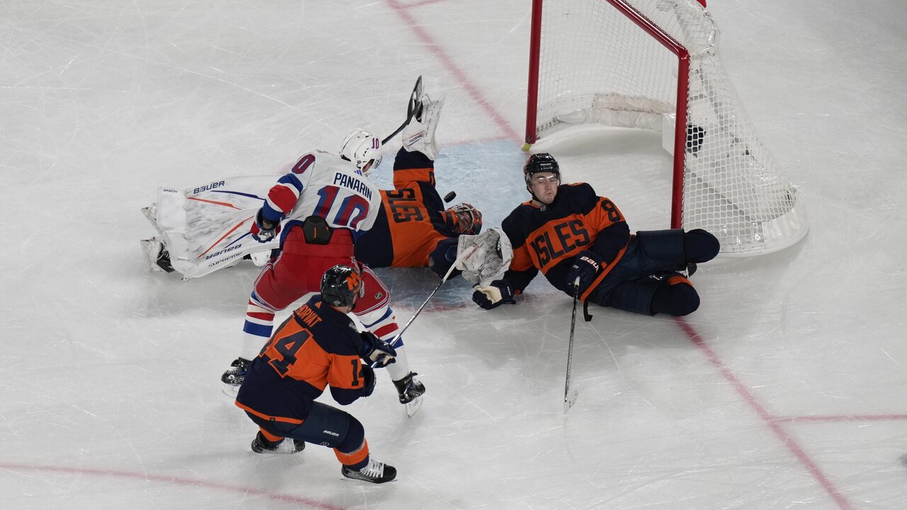 Artemi Panarin z New York Rangers (10), vľavo hore, strelil víťazný gól okolo brankára New York Islanders Ilyu Sorokina, v strede, a Noaha Dobsona, vpravo, počas predĺženia hokejového zápasu NHL Stadium Series v East Rutherford, N.J., v nedeľu 18. februára 2024.