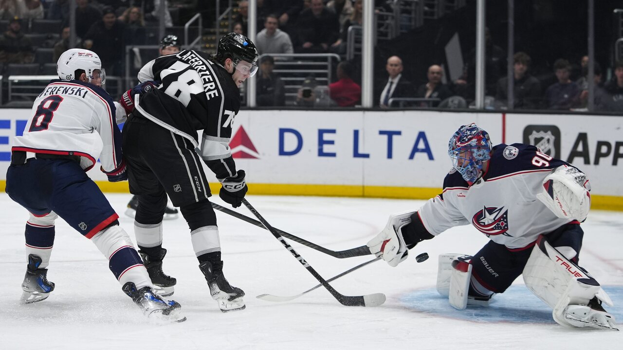 Pravé krídlo Los Angeles Kings Alex Laferriere (druhý zľava) strieľa na brankára Columbusu Blue Jackets Elvisa Merzlikinsa, zatiaľ čo obranca Zach Werenski bráni počas druhej tretiny hokejového zápasu NHL v utorok 20. februára 2024 v Los Angeles.