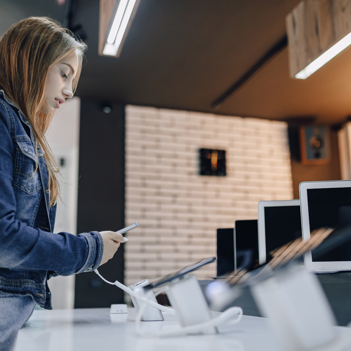 young-attractive-girl-electronics-store-stands-desk-tests-phone.jpg